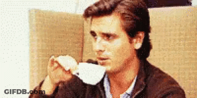 A Man Is Drinking A Cup Of Coffee From A White Cup GIF