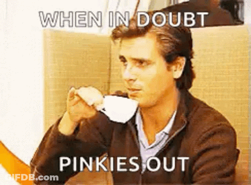 A Man Is Drinking A Cup Of Coffee While Sitting At A Table With A Meme . GIF