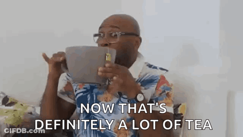 A Man Is Drinking A Cup Of Tea From A Large Mug . GIF