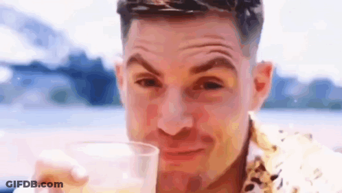 A Man Is Drinking A Glass Of Beer And Making A Face . GIF