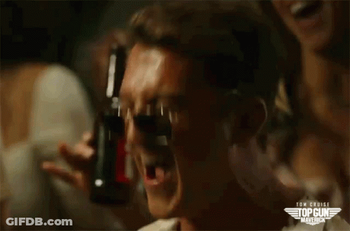 A Man Is Drinking From A Bottle With A Top Gun Maverick Logo On The Bottom GIF