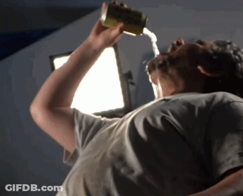 A Man Is Drinking From A Can With Water Pouring Out Of It Into His Mouth GIF