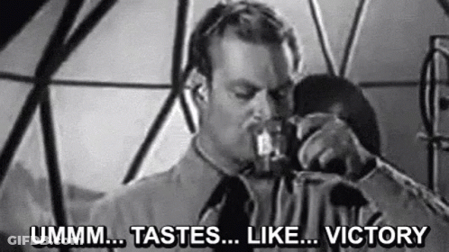 A Man Is Drinking From A Glass In A Black And White Photo With The Words `` Ummm ... Tastes ... Like ... Victory '' . GIF