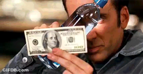 A Man Is Drinking Water From A Bottle While Holding A Dollar Bill . GIF