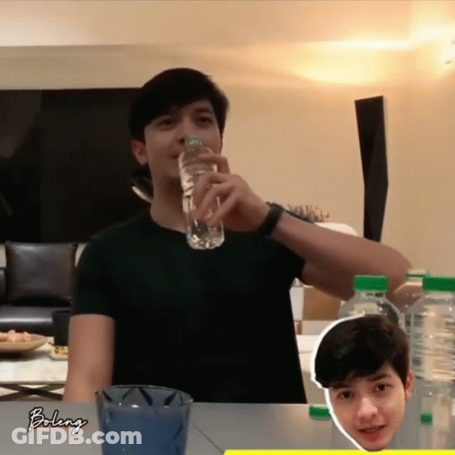 A Man Is Drinking Water From A Bottle With The Word Bolenj On The Bottom GIF
