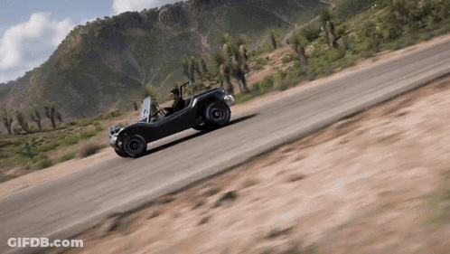 A Man Is Driving A Buggy Down A Dirt Road In The Desert GIF