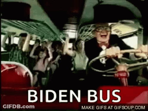 A Man Is Driving A Bus With A Crowd Of People On It And The Words Biden Bus On The Side . GIF
