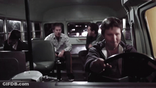 A Man Is Driving A Bus With Other People Sitting In The Back Seats GIF
