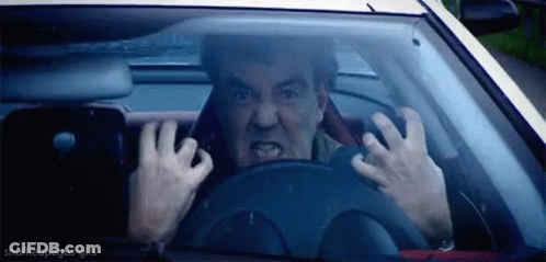 A Man Is Driving A Car And Making A Funny Face While Holding The Steering Wheel . GIF