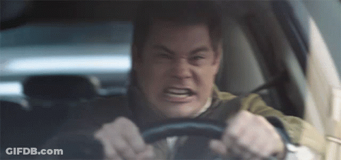 A Man Is Driving A Car And Making A Very Angry Face GIF