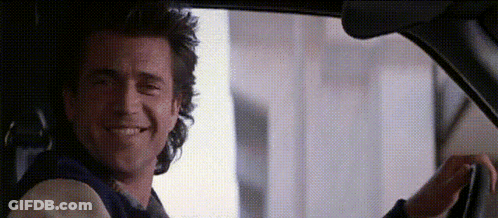 A Man Is Driving A Car And Smiling . GIF