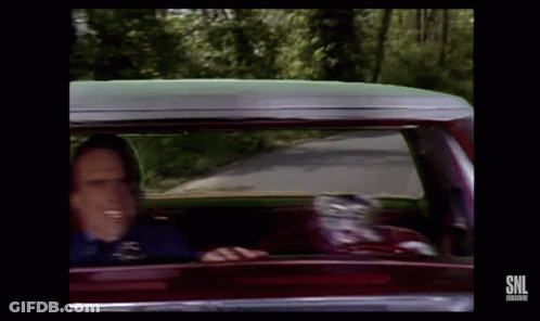 A Man Is Driving A Car And Smiling While Looking Out The Window . GIF
