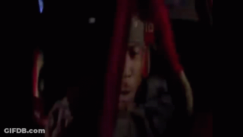 A Man Is Driving A Car And Talking On A Cell Phone While Holding A Gun . GIF