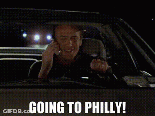 A Man Is Driving A Car And Talking On A Cell Phone With The Words Going To Philly Above Him GIF