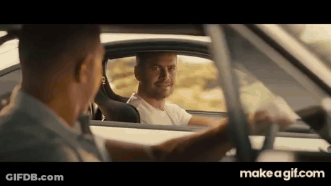 A Man Is Driving A Car And Talking To Another Man In The Driver 'S Seat . GIF