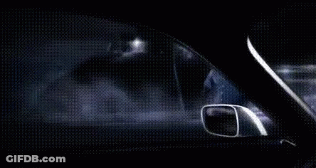 A Man Is Driving A Car At Night In The Fog . GIF