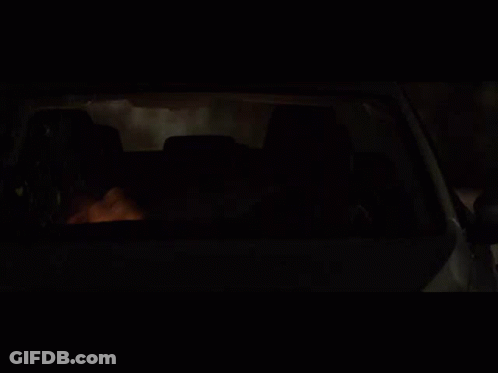 A Man Is Driving A Car At Night With His Head Out The Window GIF