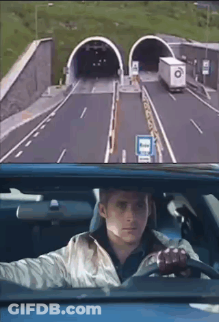 A Man Is Driving A Car Through A Tunnel And Looking Out The Window . GIF