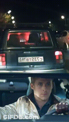 A Man Is Driving A Car With A License Plate That Says E98t2e75 GIF
