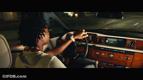 A Man Is Driving A Car With A Radio That Says ' Spotify ' On It GIF