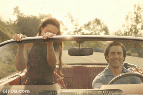 A Man Is Driving A Car With A Woman Sitting In The Back GIF