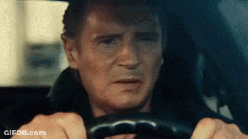 A Man Is Driving A Car With His Eyes Closed And Making A Funny Face . GIF