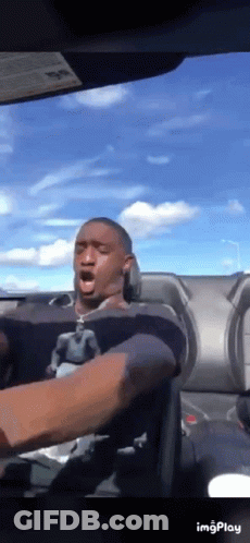 A Man Is Driving A Car With His Mouth Open .. GIF