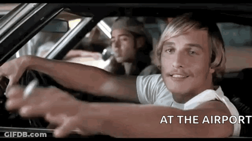 A Man Is Driving A Car With The Words `` At The Airport '' Written Above Him . GIF