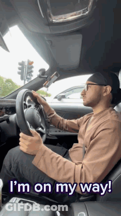 A Man Is Driving A Car With The Words `` I 'M On My Way '' Written Above Him . GIF