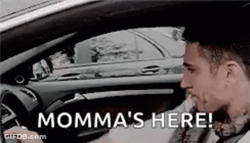A Man Is Driving A Car With The Words `` Momma 'S Here '' Written On It . GIF
