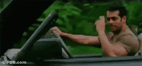 A Man Is Driving A Convertible Car And Making A Funny Face . GIF