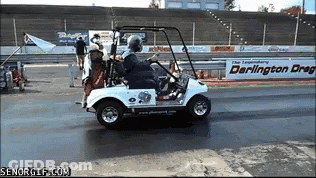 A Man Is Driving A Golf Cart On A Track With A Darlington Drag Sign In The Background GIF