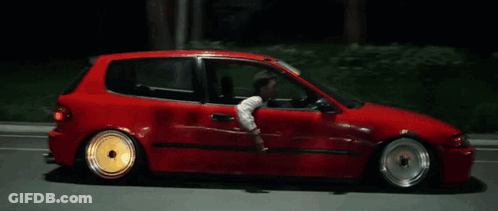 A Man Is Driving A Red Car At Night GIF