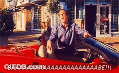 A Man Is Driving A Red Convertible With The Words Baaa On The Bottom Right GIF