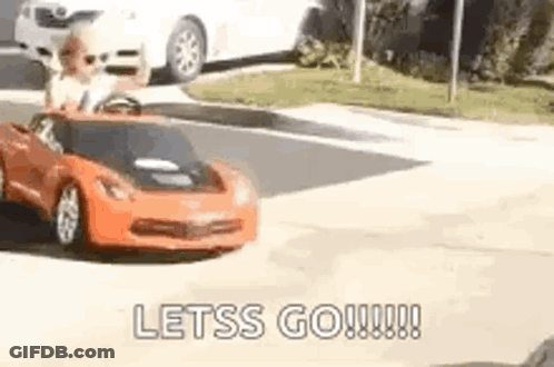 A Man Is Driving A Toy Car Down A Street . GIF