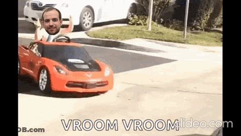 A Man Is Driving A Toy Car On A Street With A Man 'S Head Sticking Out Of It . GIF