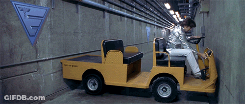 A Man Is Driving A Yellow Vehicle That Says Taylor Built GIF