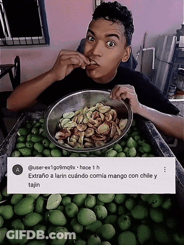 A Man Is Eating A Bowl Of Food Next To A Sign That Says A GIF