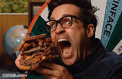 A Man Is Eating A Sandwich In Front Of A Sign That Says " Inface " GIF