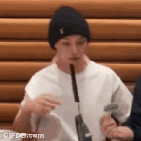 A Man Is Eating A Sausage With A Knife And Fork . GIF