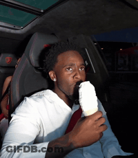 A Man Is Eating An Ice Cream Cone In The Back Seat Of A Car GIF