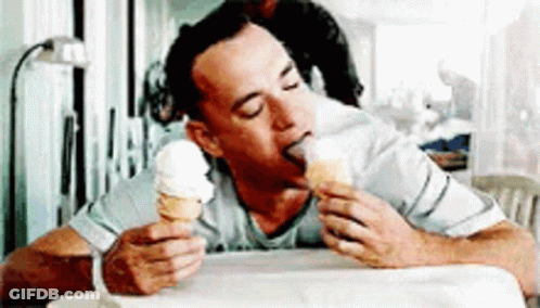 A Man Is Eating An Ice Cream Cone With His Tongue Sticking Out . GIF