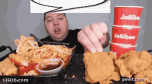 A Man Is Eating Chicken And Spaghetti With A Speech Bubble Above Him That Says Jollibee GIF