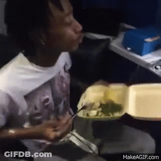 A Man Is Eating Food From A Styrofoam Container On An Airplane GIF