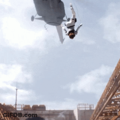 A Man Is Falling From A Helicopter In The Air GIF