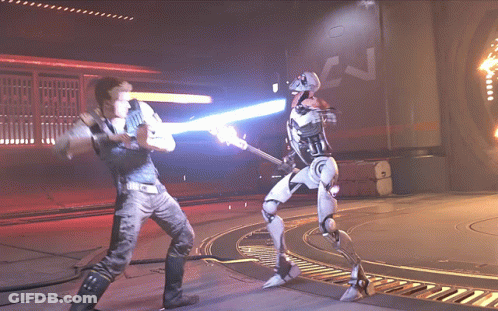 A Man Is Fighting A Robot With A Light Saber GIF