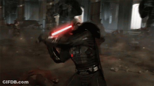 A Man Is Fighting Another Man With A Lightsaber In A Dark Room GIF