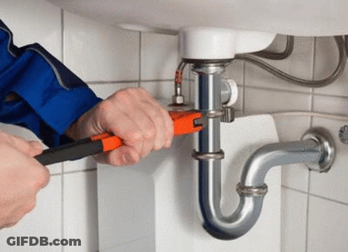 A Man Is Fixing A Sink Pipe With A Wrench . GIF