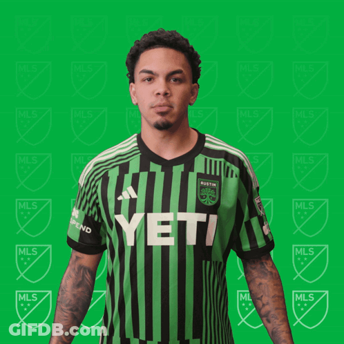 A Man Is Flexing His Muscles In A Green And Black Striped Shirt That Says Yeti GIF