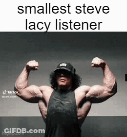 A Man Is Flexing His Muscles In A Gym . GIF